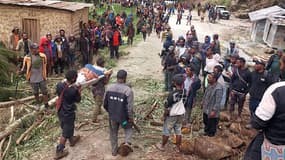 Des habitants transportant une personne sur une civière depuis le site d'un glissement de terrain dans le village de Yambali, dans la région de Maip Mulitaka, dans la province d'Enga en Papouasie-Nouvelle-Guinée, le 25 mai 2024.