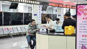 Wang Yanlong reçoit de l'argent dans un bureau administratif après son mariage début janvier, à Luliang, dans la province du Shanxi, au nord de la Chine, le 11 février 2025. 