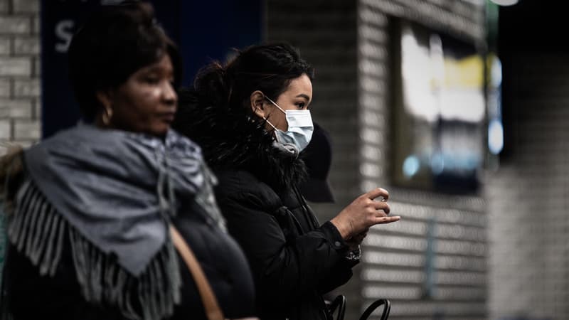 Femme avec un masque à la station Châtelet. 