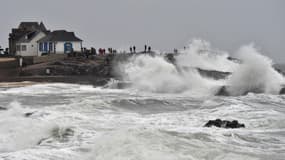 Des passants regardent les vagues s'écraser sur le littoral, le 31 décembre 2017 à Batz-sur-Mer, en Loire-Atlantique. 