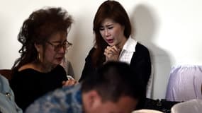 Des proches des passagers portés disparus attendent de leurs nouvelles à l’aéroport de Juanda, en Indonésie.