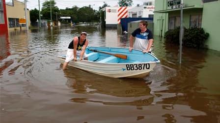 Dans une rue inondée de Brisbane. Les inondations ont continué de se propager dimanche vers le sud de l'Australie, touchant désormais quatre Etats et laissant derrière elles un paysage de désolation. /Photo prise le 13 janvier 2011/REUTERS/Tim Wimborne