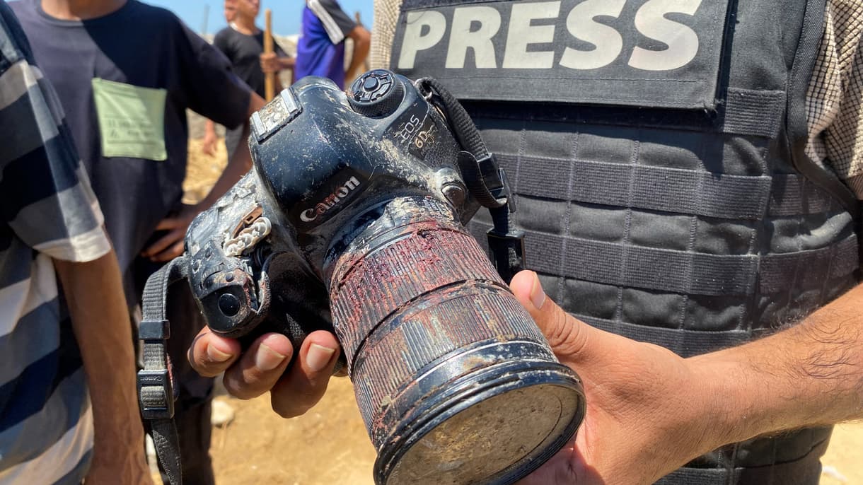 Un journaliste tient l'appareil photo couvert de sang appartenant à la photojournaliste palestinienne Mariam Dagga, journaliste indépendante pour l'AP tuée lors d'une frappe israélienne sur l'hôpital Nasser à Khan Yunis, dans le sud de la bande de Gaza, lors de ses funérailles le 25 août 2025.