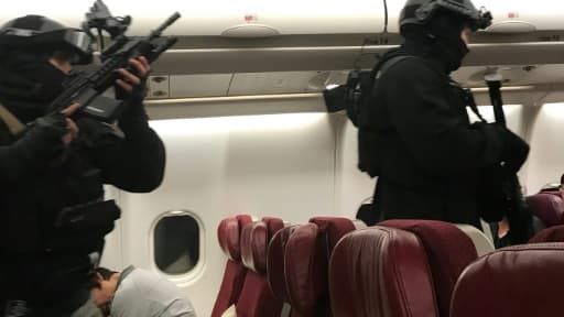 Photo fournie par un passager, Andrew Leoncelli, montrant des policiers avançant le 1er juin 2017 dans l'avion de Malaysia Airlines pour arrêter un Sri-Lankais après que le vol MH128 a atterri d'urgence à Melbourne