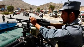 Un policier afghan surveille une rue de Kaboul à la veille de la conférence internationale des bailleurs de fonds. Les forces afghanes devraient assumer entièrement la sécurité de certaines provinces avant la fin de l'année, puis dans tout le pays d'ici 2