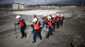 Un an après le séisme et le tsunami qui ont frappé le Japon, la police nippone continue, comme ici dans le petit port de Rikuzentakata, à chercher les corps des disparus afin de permettre aux familles de faire leur deuil et de tourner la page de cette cat