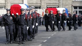 Des policiers portent les cercueils de leurs deux collègues tués la semaine dernière sur le périphérique parisien, lors de l’hommage national qui a eu lieu mardi 26 février dans la cour d'honneur de la préfecture de police de Paris.