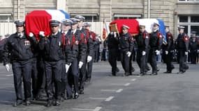 Des policiers portent les cercueils de leurs deux collègues tués la semaine dernière sur le périphérique parisien, lors de l’hommage national qui a eu lieu mardi 26 février dans la cour d'honneur de la préfecture de police de Paris.