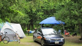 Des vacanciers en train de camper dans une zone boisée (Photo d'illustration).