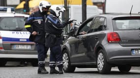 Des policiers verbalisent un contrevenant à la circulation alternée, ce lundi à Paris.