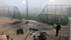 Un homme se tient près d'un portail endommagé autour d'un terrain de football après une frappe du Liban dans le village de Majdal Shams dans la zone du Golan annexée par Israël, le 28 juillet 2024.