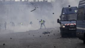 Des manifestants jetant des pavés sur des cars de CRS, sous l'arc de Triomphe