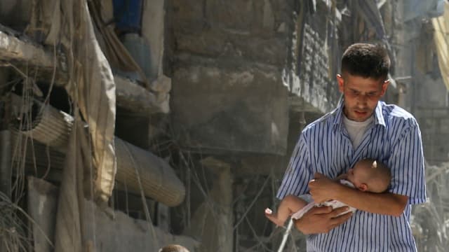 Des hommes transportant des bébés dans les ruines d'Alep, le 11 septembre.