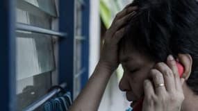 Une proche d'un passager du Boeing disparu au téléphone, le 8 mars 2014 (photo d'illustration).