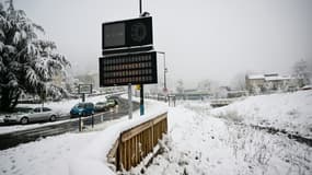Un écran affiche le message "Equipement spécial obligatoire" sur le bord d'une route après une chute de neige à Saint-Etienne, dans le sud-est de la France, le 15 mars 2025