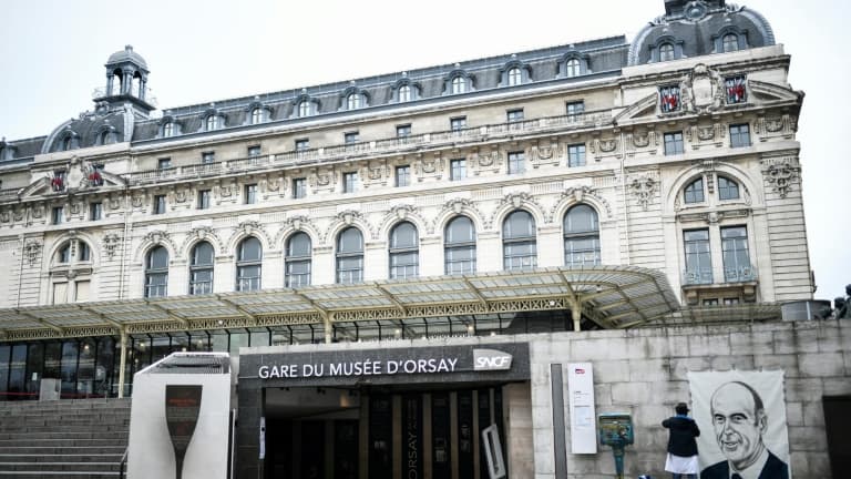 L'artiste français Roger Perez accroche un portrait de l'ancien président Valéry Giscard d'Estaing sur un mur à proximité du Musée d'Orsay à Paris le 9 décembre 2020. Giscard est décédé le 2 décembre 2020 entouré de sa famille à Authon (Loir-et-Cher)