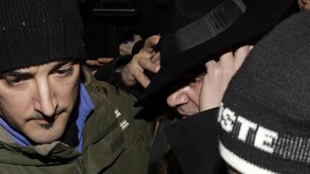 John Galliano entouré par des policiers après avoir été entendu à Paris. Christian Dior a décidé de maintenir son défilé de prêt-à-porter prévu vendredi, malgré le licenciement de son créateur vedette John Galliano, accusé d'avoir proféré des injures anti