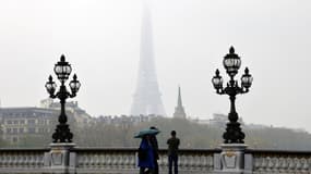 Des piétons marchent sur le pont Alexandre III par une journée brumeuse le 30 mars 2022, à Paris.