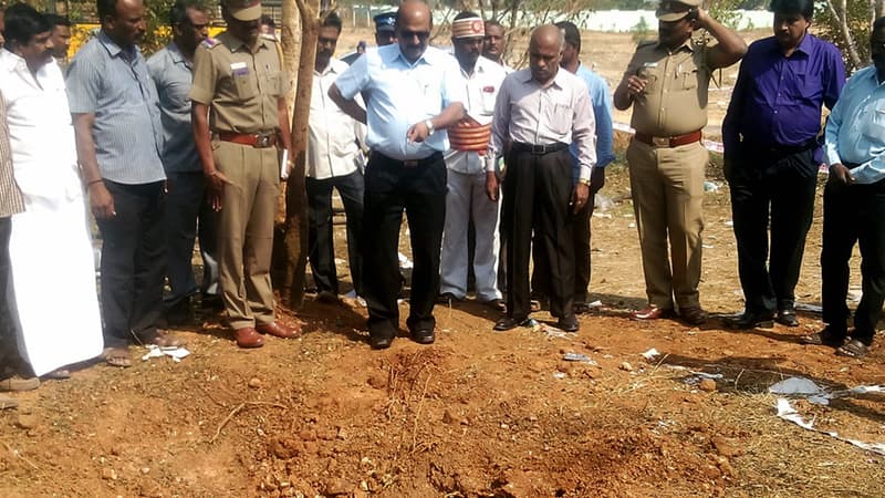 Les enquêteurs indiens devant le cratère laissé par l'objet tombé du ciel qui a tué le chauffeur de bus du campus, le 7 février.