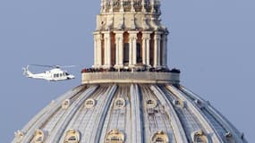 L'hélicoptère transportant Benoît XVI vers sa résidence d'été à Castel Gandolfo, après son décollage depuis le Vatican, jeudi. Le Saint-Siège désormais vacant, les cardinaux présents à Rome vont pouvoir entamer leurs "congrégations générales" préalables a