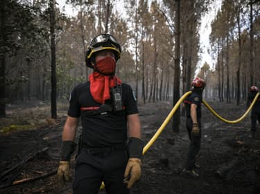 Les pompiers empêchent un incendie de reprendre à Hostens, à quelques 20 km de Landiras, dans le sud-ouest de la France, le 20 juillet 2022.
