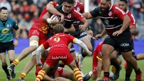 Le troisième ligne centre toulousain, Selevasio Tolofua, est plaqué par des joueurs perpignanais, lors de la 10e journée du Top 14, le 6 novembre 2021 au Stade Ernest-Wallon