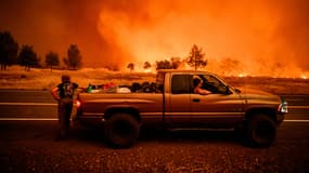 Des habitants en voiture observent la progression d'un mégafeu près de Paynes Creek, en Californie, aux États-Unis, le 27 juillet 2024