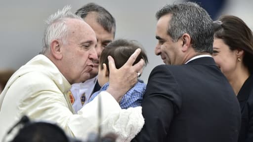 Le pape François embrasse un garçon à son arrivée  à l'aéroport de Quito le 5 juillet 2015