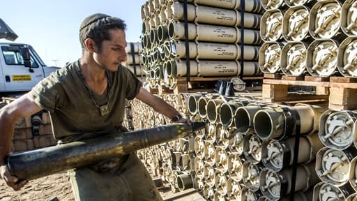 Un soldat israélien transporte des obus pour la préparation d'un tank Merkava à la frontière entre Israël et Gaza, le 31 juillet.