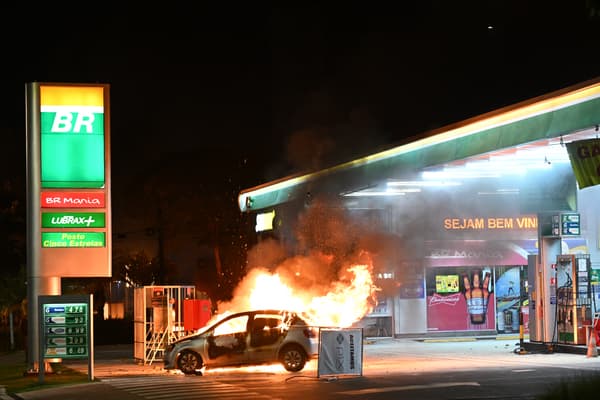 A car burns as tensions erupt between police and supporters of Jair Bolsonaro, in Brasilia, on December 13, 2022.