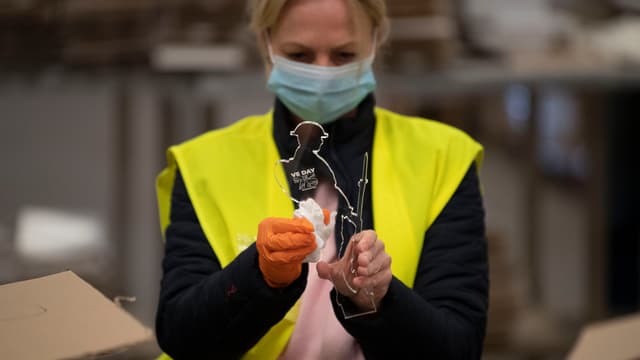 Travailleuse avec un masque au Royaume-Uni.
