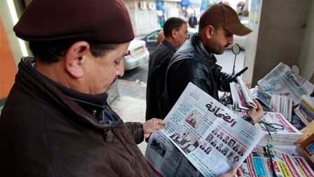 Un homme découvre la composition du nouveau gouvernement dans un journal tunisien devant un kiosque du centre de Tunis. Le remaniement annoncé jeudi pour écarter les caciques du régime de Zine ben Ali semble avoir quelque peu calmé apaisé les manifestants