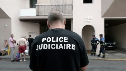 Un policier se tient devant un immeuble où cinq personnes dont un enfant sont morts dans un incendie à Pau le 10 juillet 2018