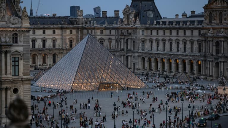 Des touristes se pressent autour de la Pyramide du Louvre, dessinée par l'architecte sino-américain Ieoh Ming Pei, à Paris, le 8 août 2024