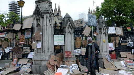 Une femme marche au travers de pancartes gisant au sol après une manifestation de solidarité avec le mouvement américain Black Lives Matter, à Londres le 7 juin 2020