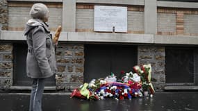 Une riveraine devant la plaque commémorative près du bar-restaurant La Belle Équipe, où 21 personnes ont été tuées par les jihadistes le 13 novembre 2015.