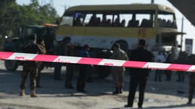 Le 20 juin 2016, en Afghanistan, des policiers positionnés devant la scène d'un attentat-suicide contre un bus, à bord duquel voyageaient des employés de sécurité népalais.