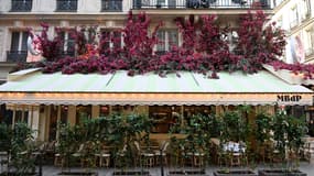 La façade d'un café décoré avec des fleurs artificielles à Paris en novembre 2022.
