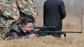 Kim Jong-Un essaye un nouveau fusil de précision lors d'une séance d'entraînement des forces spéciales, dans un lieu non précisé, en Corée du Nord, cliché communiqué le 4 avril 2025