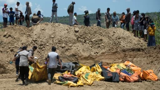 Des corps sont transportés dans une fosse commune avant une cérémonie funéraire pour les victimes du séisme à Palu sur l'île des Célèbes en Indonésie, le 1er octobre 2018