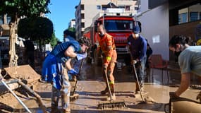 Des volontaires et des pompiers débarrassent la boue d'une rue de Massanassa, dans la région de Valence, dans l'est de l'Espagne, le 2 novembre 2024, à la suite d'inondations dévastatrices.