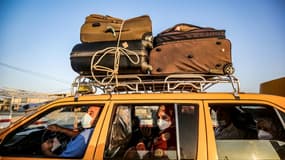 Chauffeur et pasagers portent le masque dans un taxi palestinien au passage de Rafah entre l'Egypte et la bande de Gaza le 27 septembre 2020