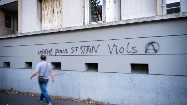Un homme passe devant un graffiti dans une rue proche de l'entrée du lycée privé catholique et du Collège Saint-Stanislas à Nantes, le 29 août 2025.