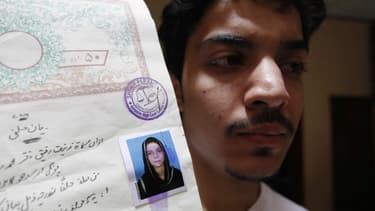 Hassan Khan montre un document avec une photo de sa défunte femme, Zeenat Bibi.