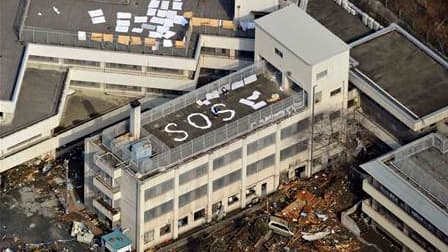 Sur le toit d'un immeuble à Kesennuma, dans la préfecture de Miyagi. Le Japon s'est réveillé samedi matin face à un spectacle de désolation après le gigantesque tremblement de terre et le tsunami qui ont touché le nord-est de l'archipel faisant plus d'un