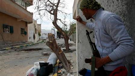 Combattant rebelle rue de Tripoli à Misrata. Si Londres, Paris et Rome s'apprêtent à dépêcher des conseillers militaires en Libye, le camp du colonel Mouammar Kadhafi comme celui des insurgés de l'Est libyen, à court de fournitures militaires de base, sem