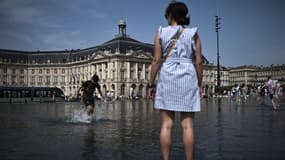 Des gens se rafraîchissent au "Miroir d'Eau" à Bordeaux, dans le sud-ouest de la France, le 30 juillet 2024.