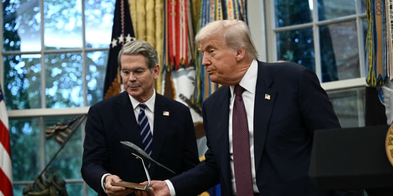 Le président américain Donald Trump remet au secrétaire au Trésor Scott Bessent une maquette d'une nouvelle version du bombardier furtif B-2 alors qu'il s'exprime dans le Bureau ovale de la Maison Blanche à Washington, DC, le 6 août 2025.
