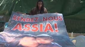 Meriam Rhaeim, la mère d'Assia, montrant une affiche intitulée: "Rendez-nous Assia !"