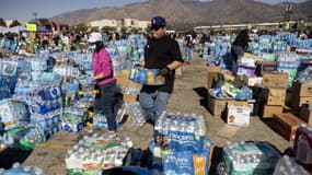 Des bénévoles distribuent de l'eau aux sinistrés à Arcadia, au nord-est de Los Angeles, le 13 janvier 2025